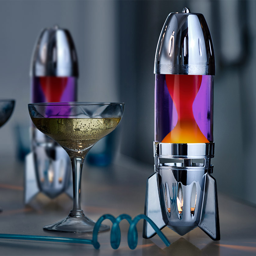 Lampe à lave à bougie Mathmos Fireflow avec corps argenté, liquide violet et lave orange, sur une table dans un intérieur élégant
