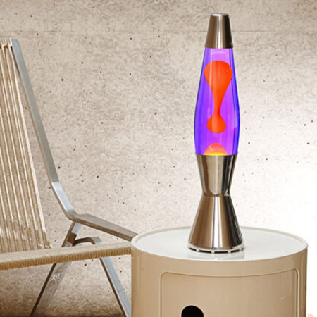 Lampe à lave argentée Mathmos Astro Baby avec liquide violet et lave orange sur une armoire dans un intérieur moderne.