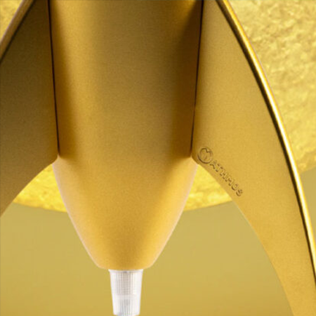 Détail de la base dorée et du logo de la lampe à lave en forme de fusée Mathmos Telstar sur un fond de couleur or.